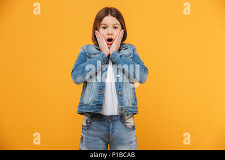 Portrait d'une écolière peu choqué à la caméra à plus de fond jaune Banque D'Images