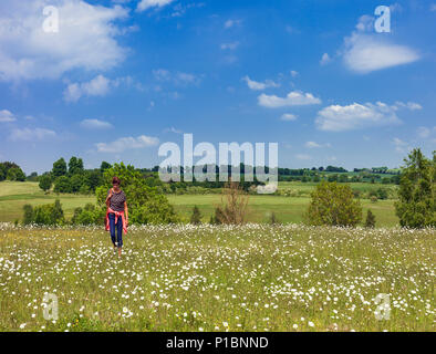 Femme marche dans une prairie de fleurs sauvages, Lullingstone, Kent, UK. Banque D'Images