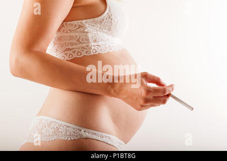 Femme enceinte cigarette isolés. Banque D'Images