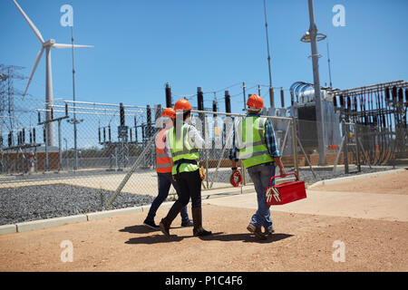 Boîte à outils avec les ingénieurs marche à sunny wind turbine power plant Banque D'Images