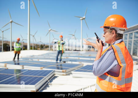 Ingénieur femelle à l'aide de talkie-walkie à alternative energy power plant Banque D'Images