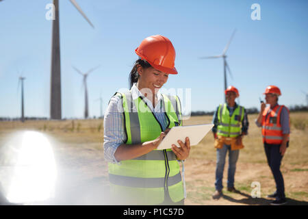 Ingénieur en souriant using digital tablet at sunny power plant Banque D'Images