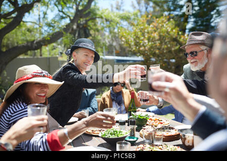 Happy friends with sunny garden party table Banque D'Images