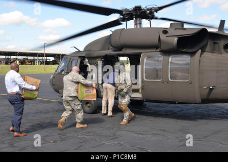 La Garde nationale de l'Armée de la Caroline du Nord et de la Caroline du Nord de l'uso de la charge du personnel 840 packs Rack '' sur un UH-60 Blackhawk à être livré à N.C. Soldats répartis dans l'Est de N.C. à l'appui de l'Ouragan Matthew effort de récupération. Chaque rack 'pack' contient un deux à trois jours d'articles de toilette gratuits et des collations. (U.S. Photo de Garde Nationale d'armée par le capitaine Michael Wilber) Banque D'Images