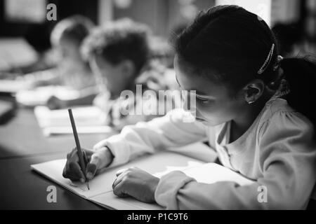 Fait ses devoirs d'écolière attentive en classe Banque D'Images