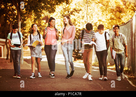 Les enfants de l'école Smiling walking on road in campus Banque D'Images