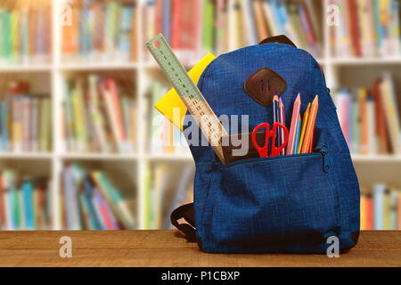 Image composite du sac de fournitures scolaires sur table en bois Banque D'Images