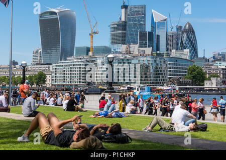 Londres, Royaume-Uni. 11 Juin, 2018. Météo britannique. La température atteint 24 degrés dans le soleil d'été à London Bridge dans la ville de Londres. Les employés de bureau et les touristes profitant de la chaleur du soleil en prenant leurs pauses de midi par la Tamise avec une vue sur la ville au-delà. L'iconic London city skylin sert de toile de fond pour les centaines de personnes profitant de la température chaude seaonal dans la capitale. Crédit : Steve Hawkins Photography/Alamy Live News Banque D'Images