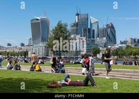 Londres, Royaume-Uni. 11 Juin, 2018. Météo britannique. La température atteint 24 degrés dans le soleil d'été à London Bridge dans la ville de Londres. Les employés de bureau et les touristes profitant de la chaleur du soleil en prenant leurs pauses de midi par la Tamise avec une vue sur la ville au-delà. L'iconic London city skylin sert de toile de fond pour les centaines de personnes profitant de la température chaude seaonal dans la capitale. Crédit : Steve Hawkins Photography/Alamy Live News Banque D'Images