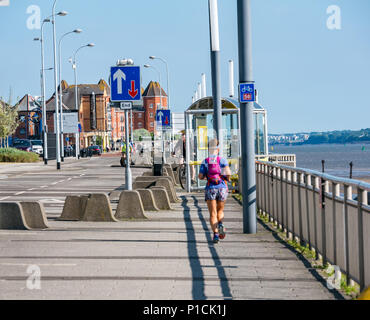 Albert Dock, Liverpool, Angleterre, Royaume-Uni, 11 juin 2018. Météo France : soleil sur la Mersey. Une belle journée ensoleillée avec ciel bleu le long de la rivière Mersey à Liverpool aujourd'hui. Une jeune femme jogger le long de la promenade sur Kings Parade Banque D'Images