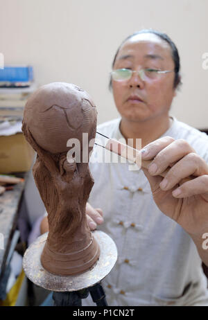 Handan, Handan, Chine. 11 Juin, 2018. Chengdu, Chine 11 juin 2018 : l'agriculteur Yan Junhai fait une sculpture en argile de FIFA World Cup Trophy en deux heures à Handan, Chine du Nord, Province de Hebei. Crédit : SIPA Asie/ZUMA/Alamy Fil Live News Banque D'Images