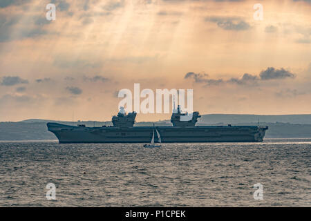 Mousehole, Cornwall, UK. 12 juin 2018. Météo britannique. C'est notablement plus froid, et un vent à travers la mer à Mounts Bay ce matin, où le porte-avions HMS QE2 est encore à l'ancre. Crédit : Simon Maycock/Alamy Live News Banque D'Images