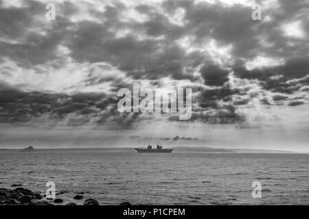 Mousehole, Cornwall, UK. 12 juin 2018. Météo britannique. C'est notablement plus froid, et un vent à travers la mer à Mounts Bay ce matin, où le porte-avions HMS QE2 est encore à l'ancre. Crédit : Simon Maycock/Alamy Live News Banque D'Images