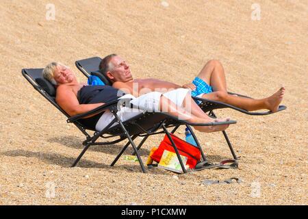 West Bay, Dorset, UK. 12 juin 2018. Météo britannique. Le soleil sur la plage, profiter de la chaleur du soleil voilé à la station balnéaire de West Bay, dans le Dorset. Crédit photo : Graham Hunt/Alamy Live News Banque D'Images