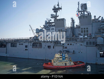 161014-N-UK248-364 SAN DIEGO (oct. 14, 2016) - Un remorqueur assiste à l'atterrissage d'assaut amphibie USS Makin Island (DG 8) qu'il quitte le quai de la station navale de San Diego pour un déploiement prévu. Makin Island est une partie de l'île de Makin groupe amphibie, qui servira aux États-Unis 3e, 5e et 7e flotte zone d'exploitation, fournissant des opérations de sécurité maritime, de la capacité d'intervention de crise, la coopération en matière de sécurité et de l'avant théâtre présence navale. (U.S. Photo de la marine du Maître de 2e classe Kristina Young/libérés) Banque D'Images