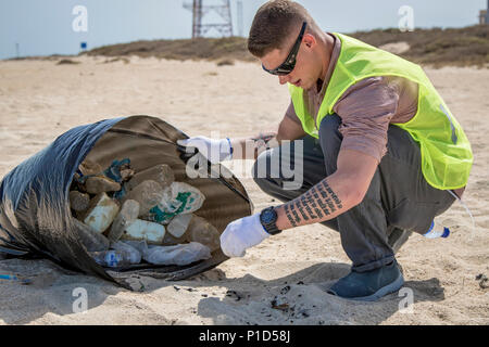 La CPS. Zackary Larrabee, un soldat de l'armée américaine avec la centrale 268e bataillon du génie picks up trash à un nettoyage de plage organisé par les bénévoles du Koweït le 15 octobre 2016 à Umm al Maradim Koweït, de l'île. Le projet a permis à cinq soldats USARCENT en faveur de l'environnement et de passer du temps avec leur pays hôte. (U.S. Photo de l'armée par le Sgt. Angela Lorden) Banque D'Images