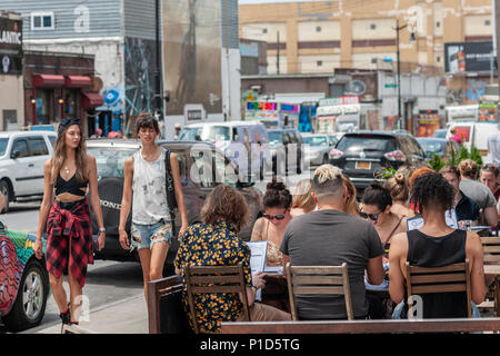 Manger en plein air à Bushwick, Brooklyn à New York lors de l'assemblée annuelle Collective Bushwick Block Party le samedi 2 juin 2018. La musique et faire la fête a certains mais la véritable attraction est le nouveau 'des peintures murales réalisées par des artistes graffiti qui ornent les murs des bâtiments que la convention collective. (Â©Â Richard B. Levine) Banque D'Images