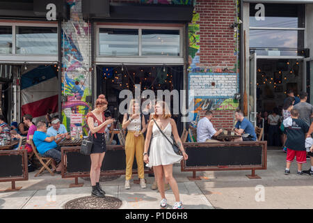 Manger en plein air à Bushwick, Brooklyn à New York lors de l'assemblée annuelle Collective Bushwick Block Party le samedi 2 juin 2018. La musique et faire la fête a certains mais la véritable attraction est le nouveau 'des peintures murales réalisées par des artistes graffiti qui ornent les murs des bâtiments que la convention collective. (© Richard B. Levine) Banque D'Images