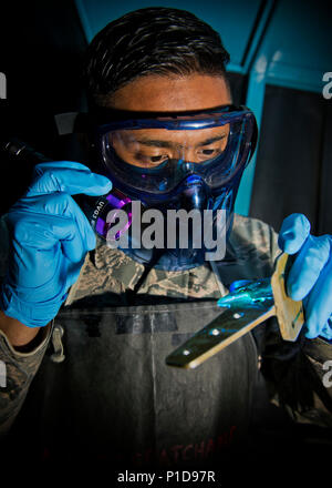 Navigant de première classe Alexander Shaikh, 5e Escadron de maintenance contrôle non destructif compagnon, brille une lumière noire lors d'un contrôle par ressuage fluorescent à Minot Air Force Base, N.D., le 18 octobre 2016. La lumière noire sida Shaikh à repérer les fissures et imperfections sur les pièces du B-52H Stratofortress et du matériel de soutien des aéronefs. (U.S. Air Force photo/Navigant de première classe J.T. Armstrong) Banque D'Images