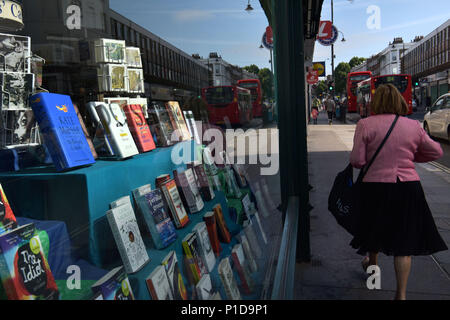 Les gens passent devant une librairie indépendante sur Kentish Town Road. Boutiques ferment et la rue principale est en déclin comme les gens se déplacent pour faire leur sho Banque D'Images