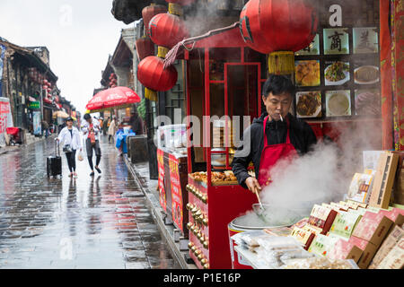 PINGYAO, CHINE - le 21 mai 2018 : les touristes et les populations locales dans la ville antique de Pingyao dans le centre de la Chine, de l'Asie. Temps de pluie. Banque D'Images