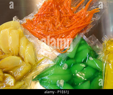 Poires Pommes carottes et autres légumes cuits sont emballées sous vide dans des conteneurs Banque D'Images