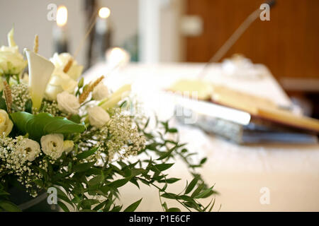 Vase de beaucoup de fleurs sur un autel dans l'église et de la bible sur l'arrière-plan Banque D'Images