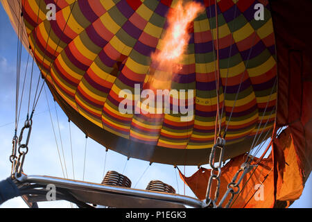 Une montgolfière en vol au-dessus de S. Wiltshire, avec les brûleurs à flamme de l'altitude : de l'intérieur de la nacelle du ballon. Banque D'Images