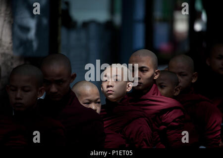 Monks patiemment la file d'attente à l'heure du déjeuner au monastère Mahagandhayon Banque D'Images