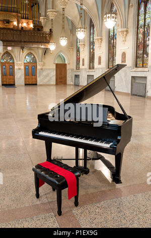 Baby Grand piano avec couvercle ouvert prêt Prêt à jouer et en attente d'un musicien dans un grand hall de l'église gothique, en Pennsylvanie. Banque D'Images