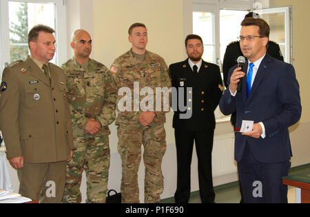 STARGARD, Pologne - commissaire du comté de Stargard Ireneusz Rogowski (à droite) félicite les représentants des États-Unis alliées, Polonais, et des forces canadiennes y compris (de gauche à droite) Le colonel polonais Marek Gmurski, commandant, Szczecin, zone d'entraînement de l'armée des États-Unis 1er Sgt. Anthony Dimico, senior advisor enrôlés de la société D, 2e Bataillon, 503e Régiment d'infanterie, 173e Brigade aéroportée, et le 1er lieutenant Bailey Hullett, chef de section, D Co., 2e Bn., 503e Inf. Regt., pour leur encadrement d'officiers subalternes de réserve local' Training Corps de cadets. Les "soldats du ciel" de D Co., 2e Bn., 503e Inf. Regt., sont sur Banque D'Images