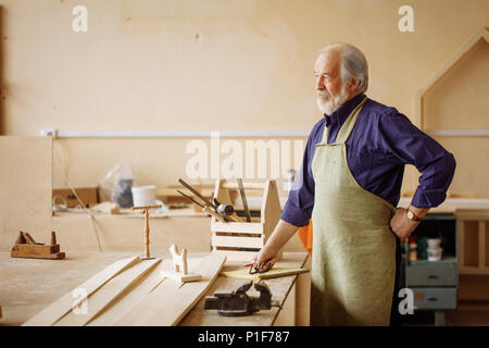 Close up side view image de fatigué pensive pension dans l'atelier de réparation Banque D'Images