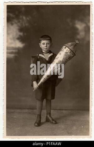 EILENBURG, ALLEMAGNE - VERS 1920s: La photo d'époque montre élève garçon avec cône scolaire. Photo de studio avec teinte sépia. 1920s Banque D'Images