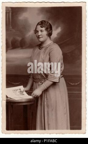 EILENBURG, ALLEMAGNE - VERS 1920s: Photo d'époque montre la femme mûre pose avec le livre dans un studio de photographie. Portrait de studio noir et blanc antique. 1920s. Banque D'Images