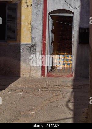 Grunge fond urbain éclairé d'une porte d'entrée avec des carreaux et des ombres autour. Banque D'Images