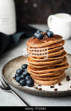 Crêpes de sarrasin et de farine d'avoine. Pancakes vegan sain. Des crêpes au chocolat avec des bleuets. Vue rapprochée, selective focus Banque D'Images