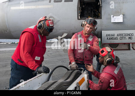 Maître de 1re classe Malcom Hines (centre), du comté de Polk, North Carolina, affecté à la "Dambusters" de Strike Fighter Squadron (VFA) 195, supervise le chargement de 20 mm sur un F/A-18E Super Hornet à bord de la Marine a seulement l'avant-déployé, porte-avions USS Ronald Reagan (CVN 76). Le F/A-18E Super Hornet est équipé d'un nez-monté M6182 canon 20 mm feux ronds. Ronald Reagan, le groupe aéronaval du porte-étendard, cinq est en patrouille soutenir la sécurité et la stabilité dans la région du Pacifique-Indo-Asia. (U.S. Photo de la marine par le maître de 3e classe James Lee/libérés) Banque D'Images