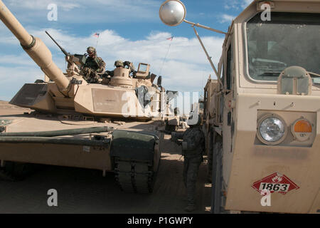 Soldat américain M1A2 Abrams tank d'équipages de la 3e Bataillon, 8e régiment de cavalerie blindée, 3e Brigade Combat Team, 1re Division de cavalerie rouler à travers un point de carburant au cours de la partie de la brigade d'incendie au cours de la National Training Centre 17-01 à Fort Irwin, en Californie, le 13 octobre 2016. NTC 17-01 fournit des unités militaires américaines et du personnel avec une formation préalable au déploiement réaliste scénarios dans tous les aspects des conflits armés. (U.S. Photo de l'armée par le sergent. Leah Kilpatrick) Banque D'Images