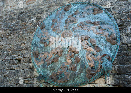 Belle gravure sur un abri du trou circulaire dans la vieille ville de gruyère, en Suisse. Détail de chiffres de couleur bronze bleu-gris retour contre Banque D'Images