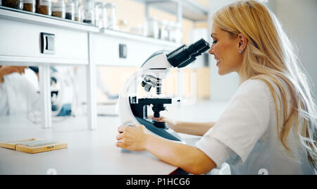 Grâce à la jeune scientifique microscope in laboratory Banque D'Images