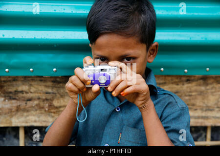 Un jeune garçon réfugié Rohingya avec son jouet à l'appareil photo du camp de réfugiés de Kutupalong à Ukhiya à Cox's Bazar, Bangladesh Banque D'Images