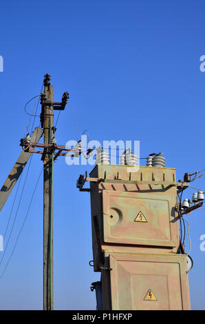 Vieux et obsolètes de transformateur électrique dans le contexte d'un ciel bleu. Dispositif pour la distribution de fourniture de l'énergie à haute tension Banque D'Images