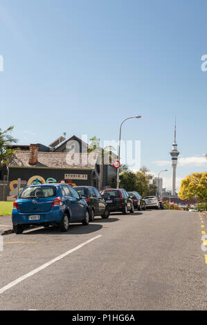 Rue de banlieue dans la région de Ponsonby avec voitures garées et Auckland Sky Tower en arrière-plan de la capitale de la Nouvelle-Zélande Banque D'Images