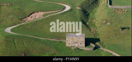 Grange avec une piste sinueuse dans Stonesdale il passé dans le Yorkshire Dales National Park, Royaume-Uni. Banque D'Images