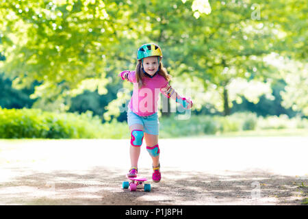 Child riding skateboard park en été. Petite fille à apprendre à faire du vélo skate board. Sport actif à l'extérieur pour l'école et le jardin d'enfants. Enfants skat Banque D'Images