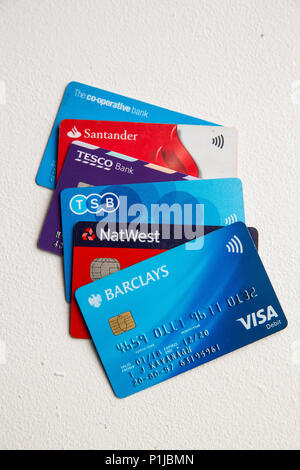 Cinq cartes de débit de visa dans un tas sur un fond blanc, dont Tesco, TSB, Barclays, Co-op, NatWest et Santander. Banque D'Images