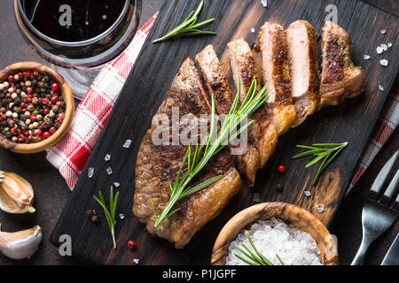 Steak de faux-filet de bœuf grillé avec verre de vin rouge. Vue d'en haut. Close up. Banque D'Images