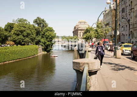 Marcher le long de la rivière Vltava avec Slovansky ostrov à gauche et Théâtre National des capacités dans la distance à Prague, République Tchèque Banque D'Images