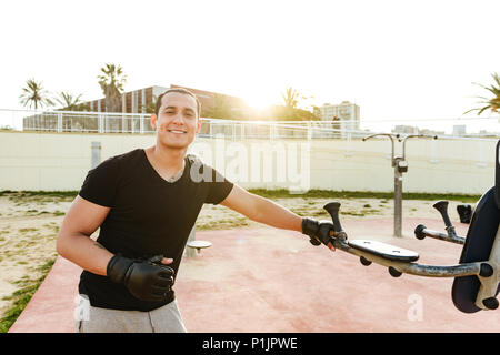 Photo de jeunes professionnels strong man sports plein air boxer faire des exercices dans les gants. À la caméra. Banque D'Images