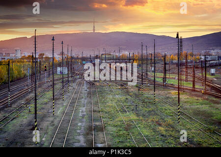 Former des rails de chemin de fer au coucher du soleil, Bratislava. Banque D'Images